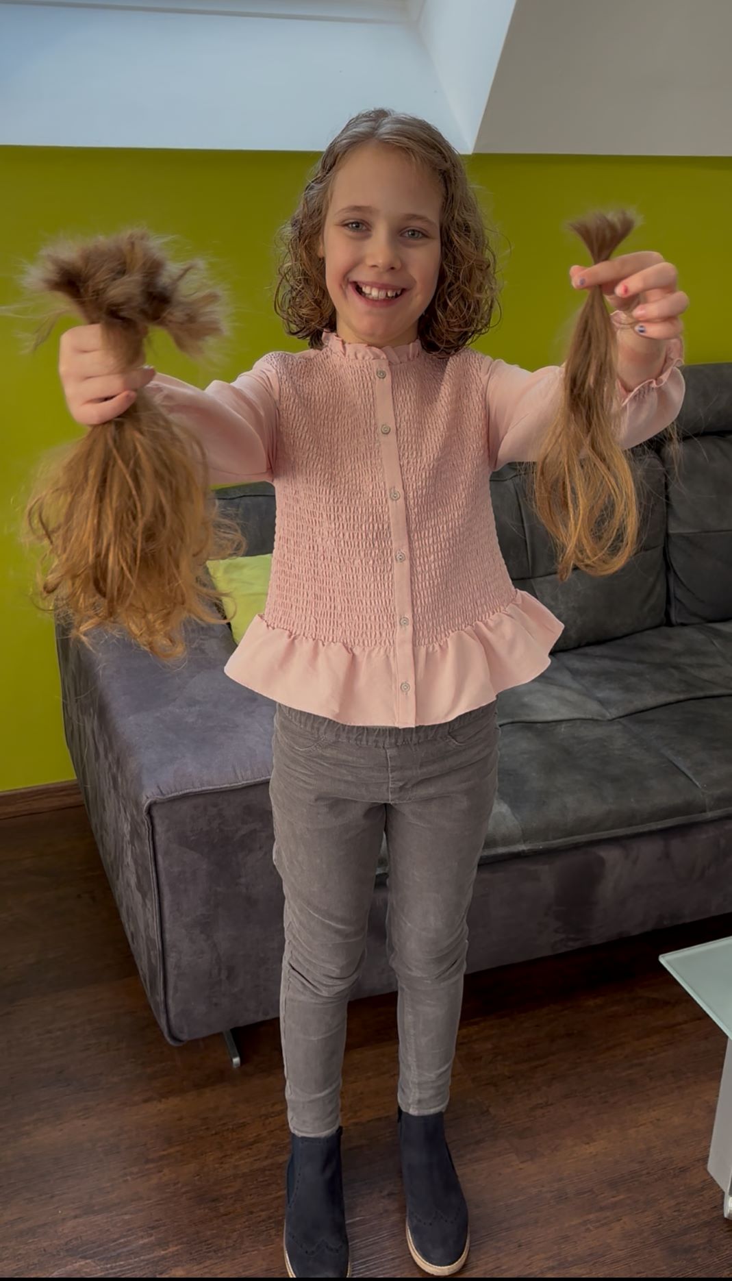 Victoria hält stolz die abgeschnittenen Zöpfe hoch